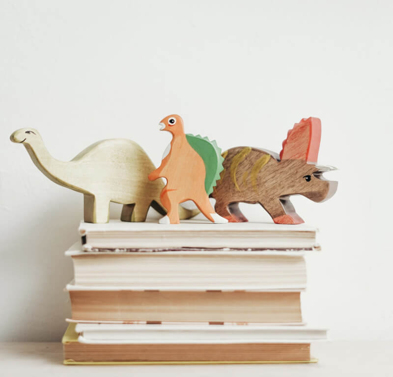 a trio of wooden dinosaur toys